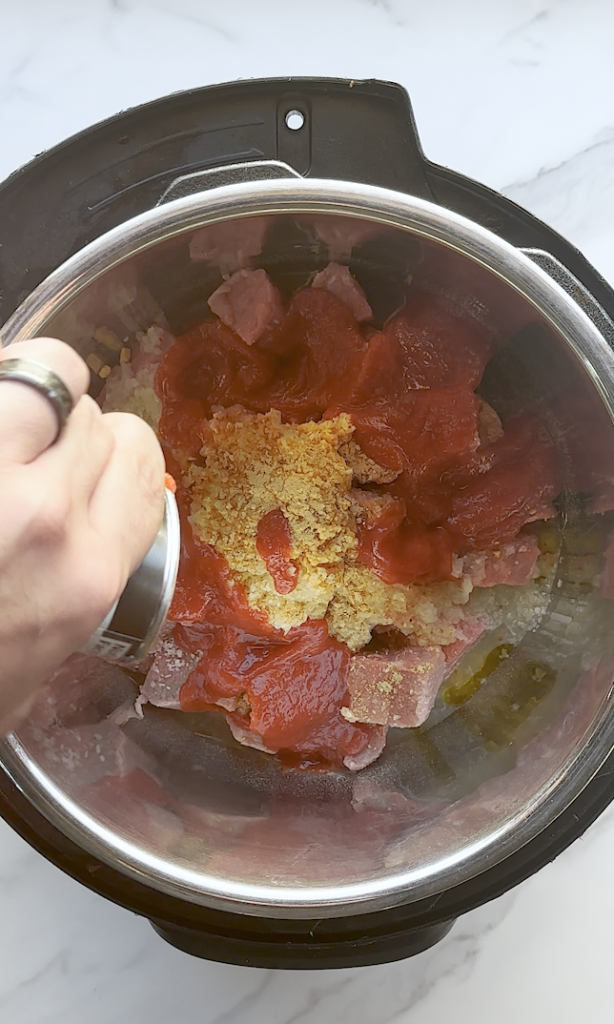 chunks of beef cut in 3 inch squares for beef korma and with onions over the top and other seasonings/sauces